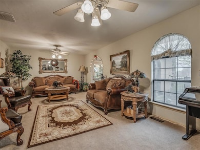 Carpeted living room featuring visible vents, a we