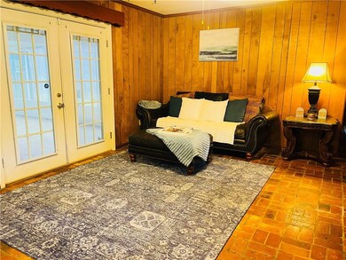 Living area featuring brick floor, wood walls, and