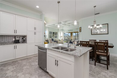Kitchen with white cabinets, pendant lighting, sta
