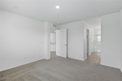 Unfurnished bedroom with light colored carpet, connected bathroom, and recessed lighting