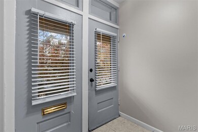 Doorway featuring tile patterned flooring and baseboards