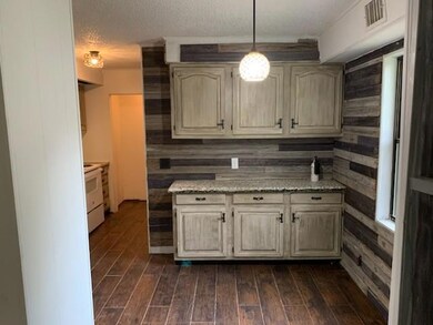 Kitchen with a textured ceiling, dark hardwood / w