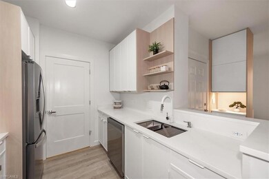 Kitchen featuring appliances with stainless steel finishes, light wood-type flooring, light countertops, and open shelves