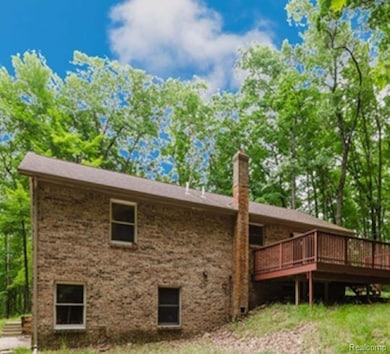 Back of house with a chimney and a deck