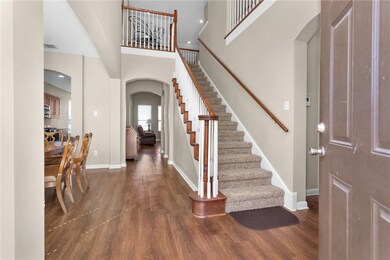 Foyer with wood finished floors, arched walkways,