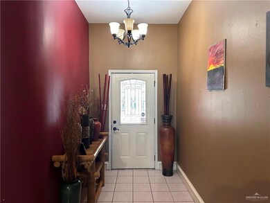Entrance foyer featuring light tile patterned flooring and an inviting chandelier