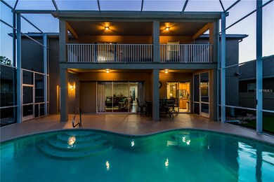 View of pool area to home showcasing balcony and l