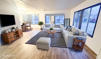 Living area featuring light wood-type flooring and a chandelier