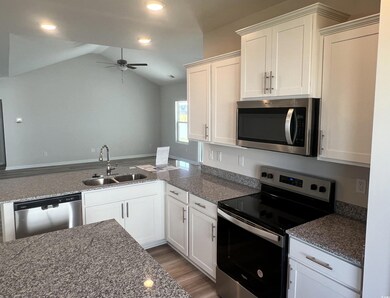 Kitchen featuring vaulted ceiling, appliances with
