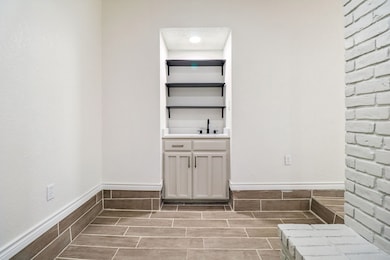 Washroom featuring baseboards and a sink