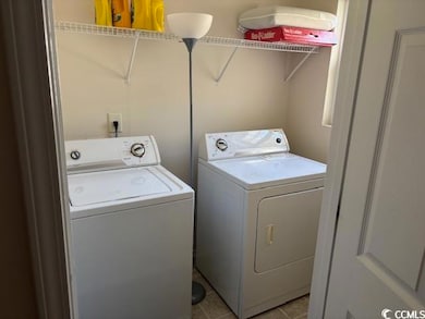 Laundry room featuring separate washer and dryer and light tile patterned flooring