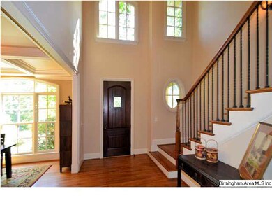 Two story foyer is open to formal dining room on l
