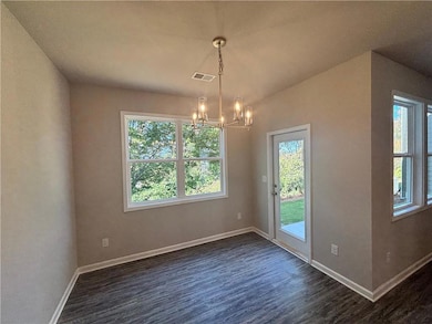 Unfurnished dining area featuring dark hardwood / 