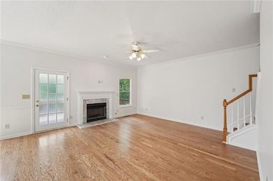 Unfurnished living room with ceiling fan, crown mo