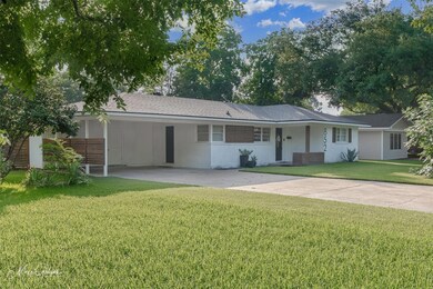 Ranch-style house with a front lawn and a carport
