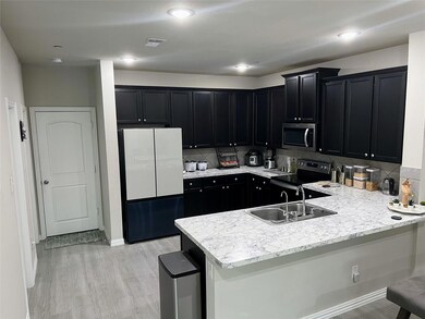 Kitchen featuring tasteful backsplash, light wood-type flooring, a kitchen breakfast bar, and stainless steel appliances