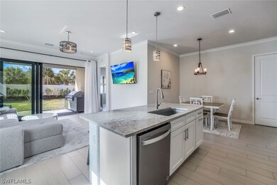 Kitchen with white cabinetry, pendant lighting, si