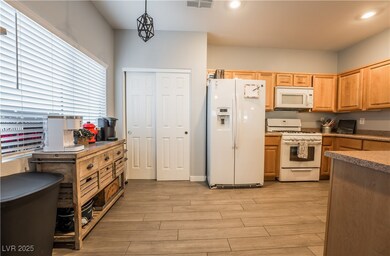 Kitchen with white appliances, light wood-style fl