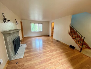 The living room has laminate flooring and a stone fireplace with gas logs.  There is a ceramic tile entry.
