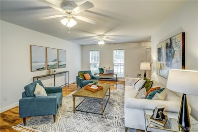 Living room with ceiling fan and hardwood / wood-style floors