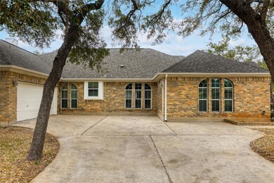 Back of property featuring a shingled roof, an at