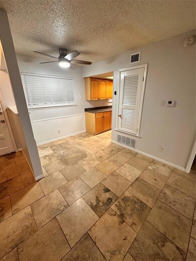 Kitchen with a textured ceiling, a ceiling fan, d