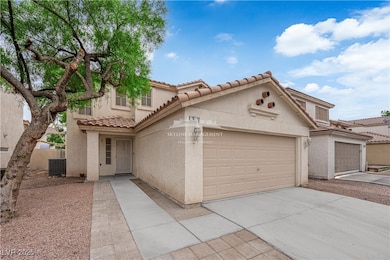 Mediterranean / spanish-style house featuring stucco siding, driveway, a tile roof, and a garage