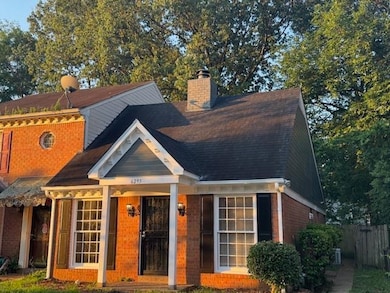 View of front of home with a chimney and brick siding