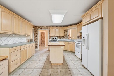Kitchen with wallpapered walls, white appliances, 