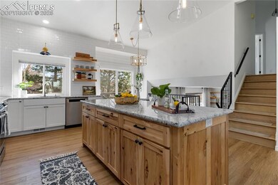 Kitchen with light stone counters, a kitchen islan