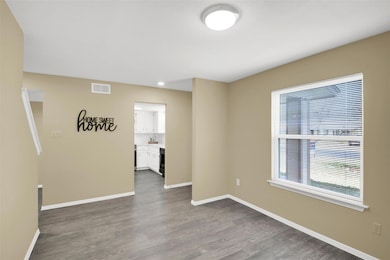 Spare room featuring dark wood finished floors, b