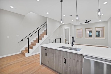 Kitchen with light wood-style flooring, modern cab
