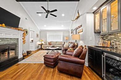 Living room with a stone fireplace, wet bar, wood-
