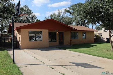 View of front facade with a front yard, stucco siding, and a patio