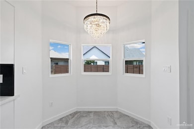 Unfurnished dining area featuring a chandelier and a high ceiling