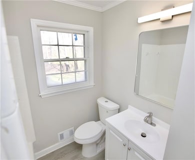 Full bathroom featuring toilet, vanity, wood finis