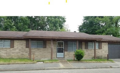 It features a covered front porch, a small front y