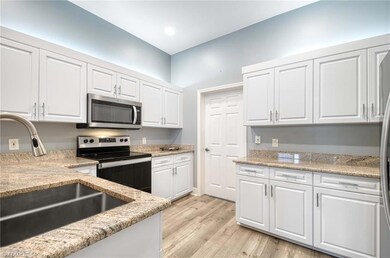 Kitchen featuring white cabinets, sink, and applia