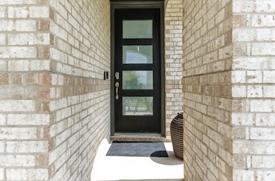View of exterior entry featuring brick siding