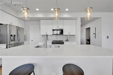 Kitchen with pendant lighting, appliances with sta