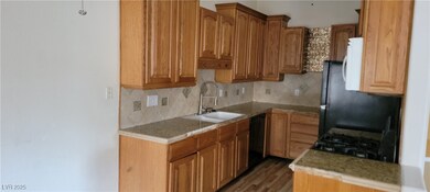 Kitchen with a sink, black dishwasher, backsplash,
