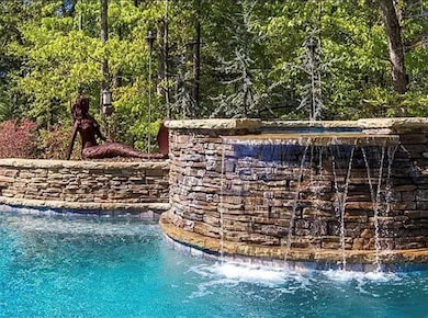 Swimming pool featuring a wooded view