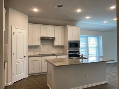 Kitchen with white cabinets, dark wood-style floo