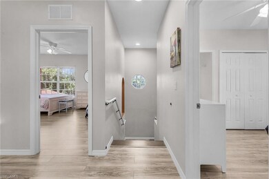 Corridor featuring light wood-style flooring, an upstairs landing, and recessed lighting