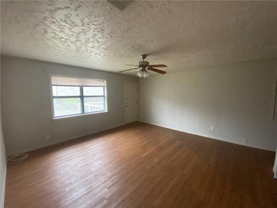 Unfurnished room featuring a ceiling fan, wood fi