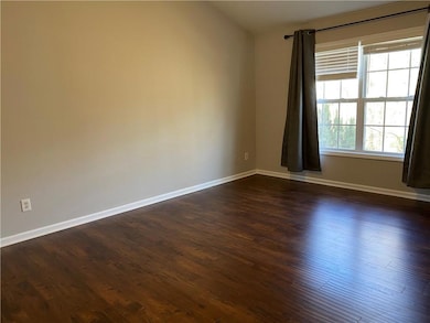 Unfurnished room with baseboards and dark wood finished floors