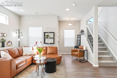 Living area featuring wood finished floors, plenty of natural light, stairs, recessed lighting, and baseboards
