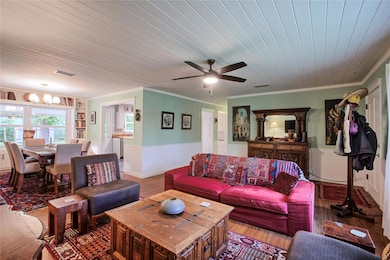 Living area with crown molding, visible vents, wo