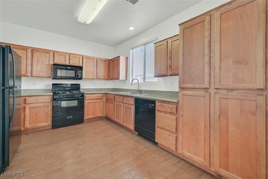 Kitchen featuring black appliances, a sink, light