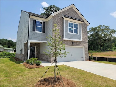View of front facade with an attached garage, driveway, and brick siding